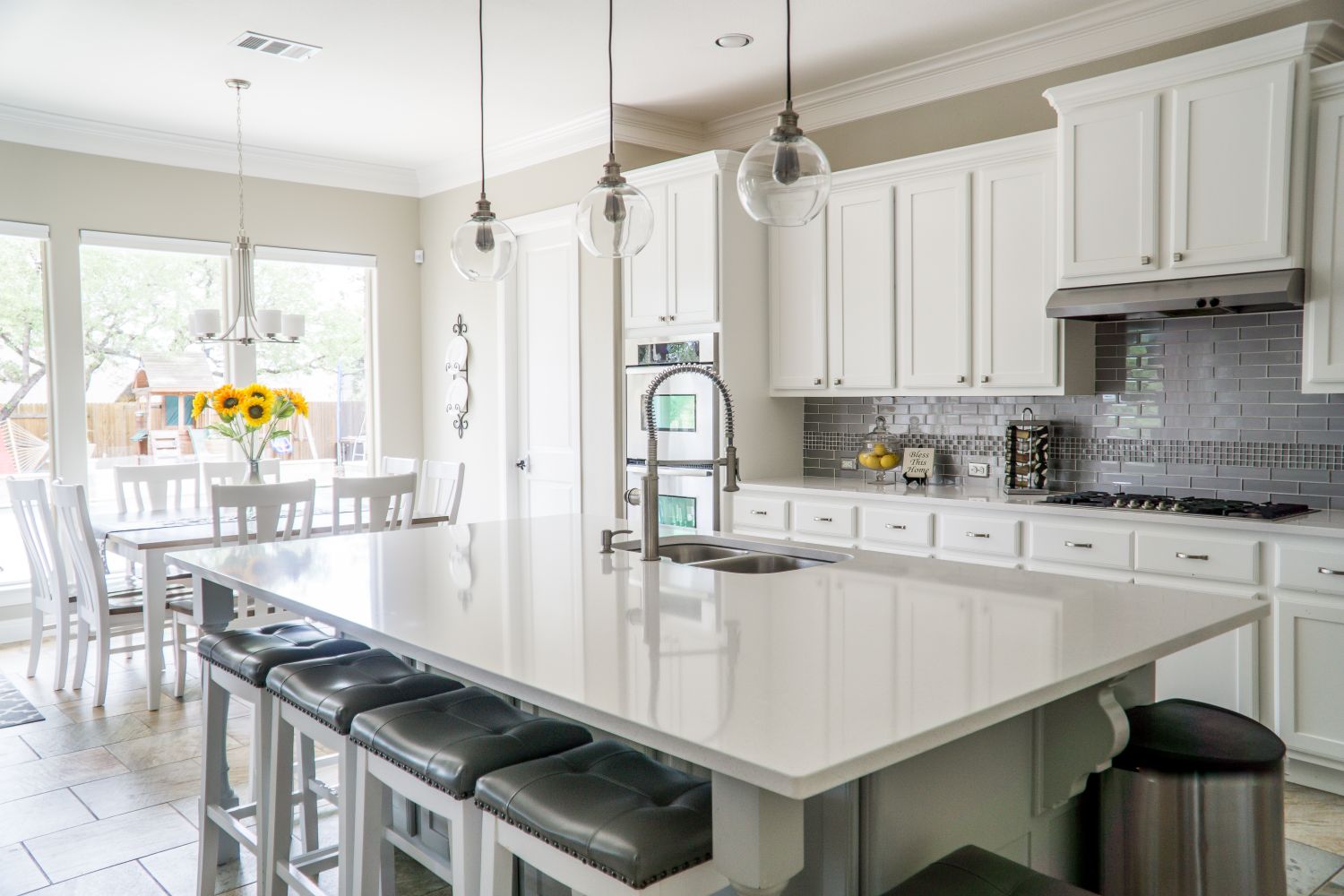 A renovated open-plan kitchen with custom cabinetry, island and pendant lighting