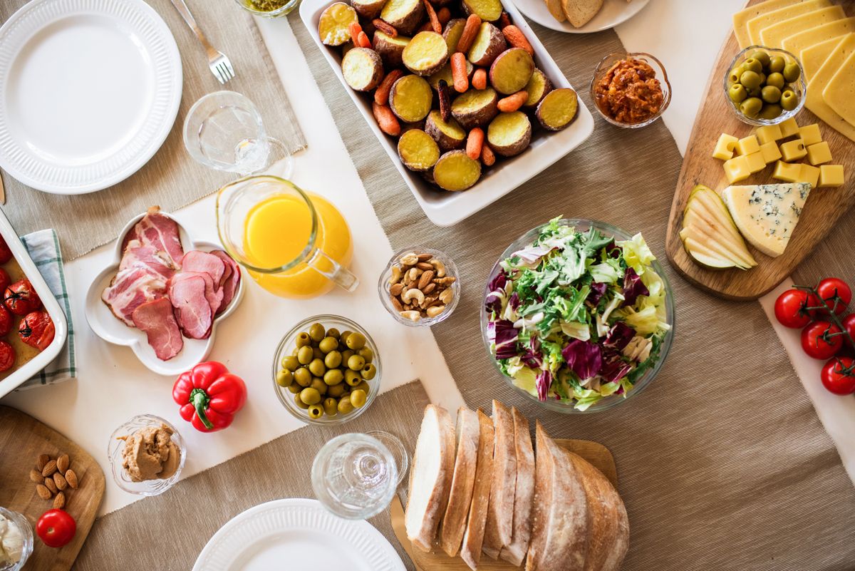 An Italian antipasto spread of cured meats, olives, cheese and bread on a wooden table