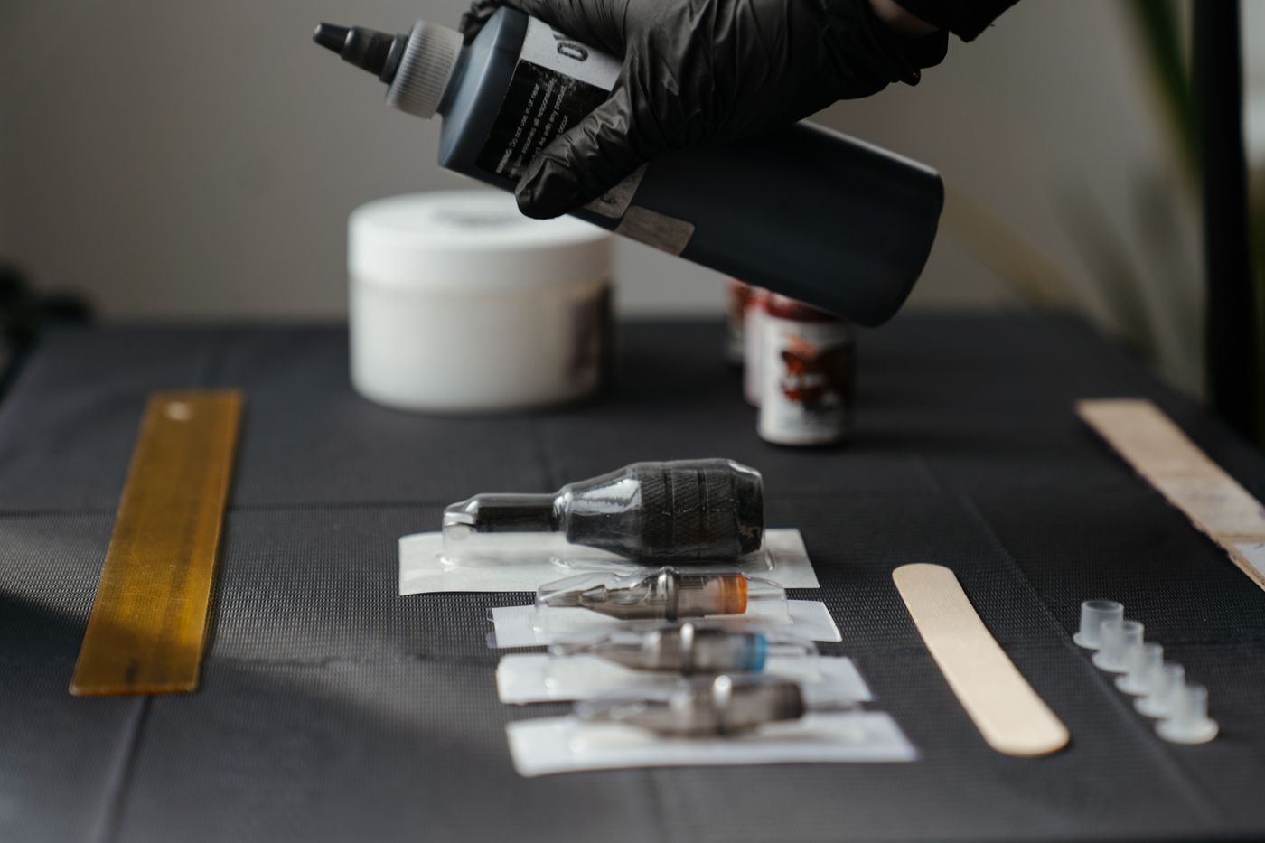 Tattoo machine and tools on a dark surface