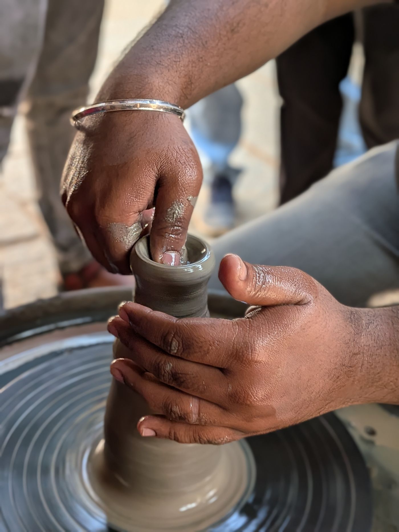 Hands centring clay on the wheel