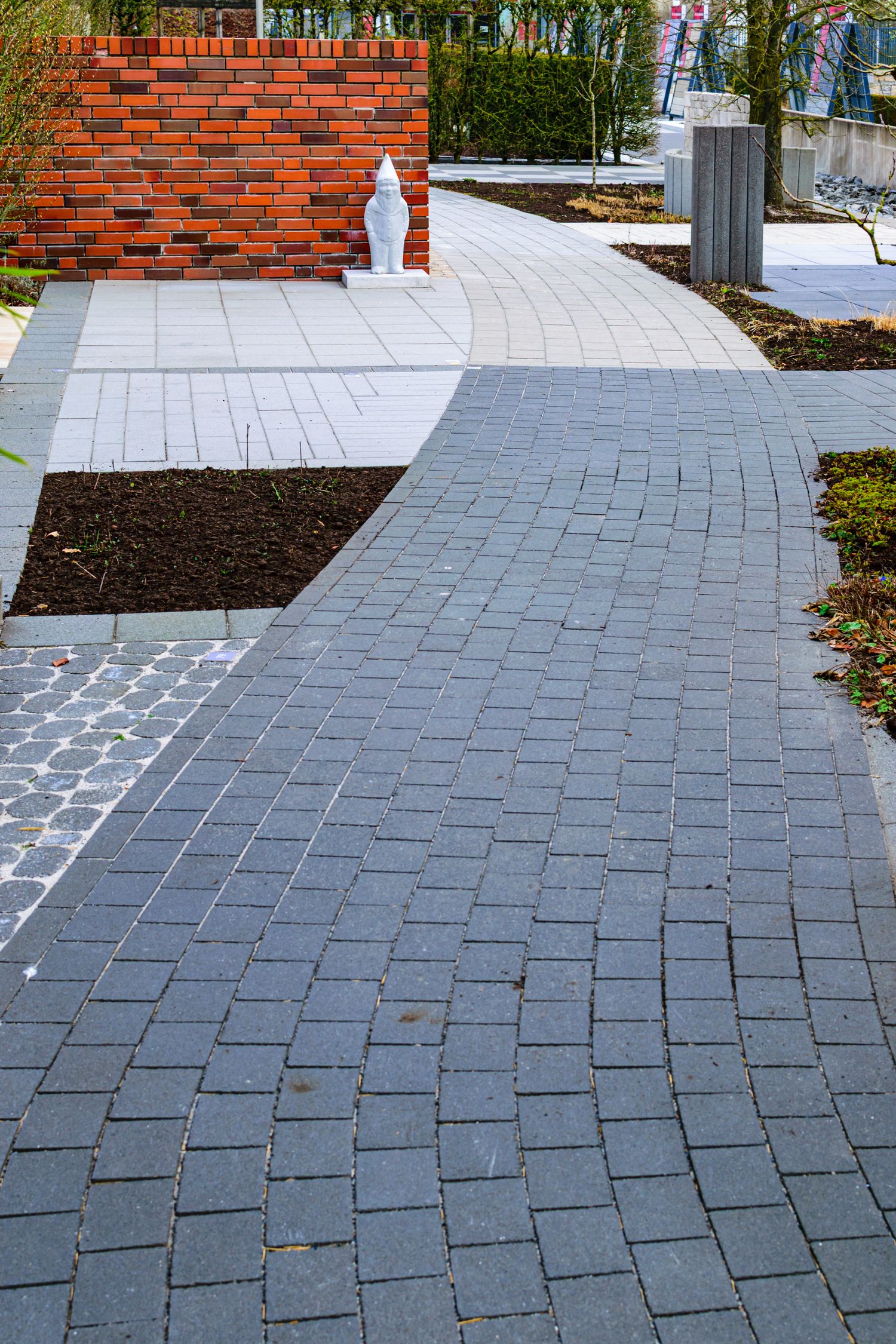 A curved brick walkway through a garden