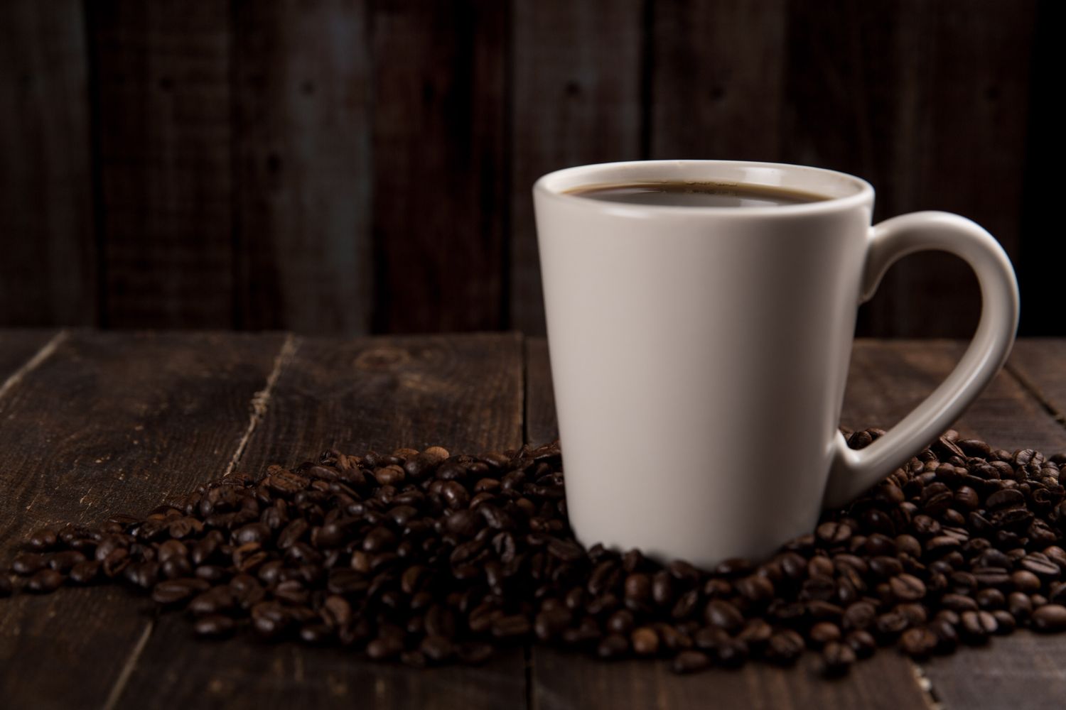 Mug of coffee resting on beans