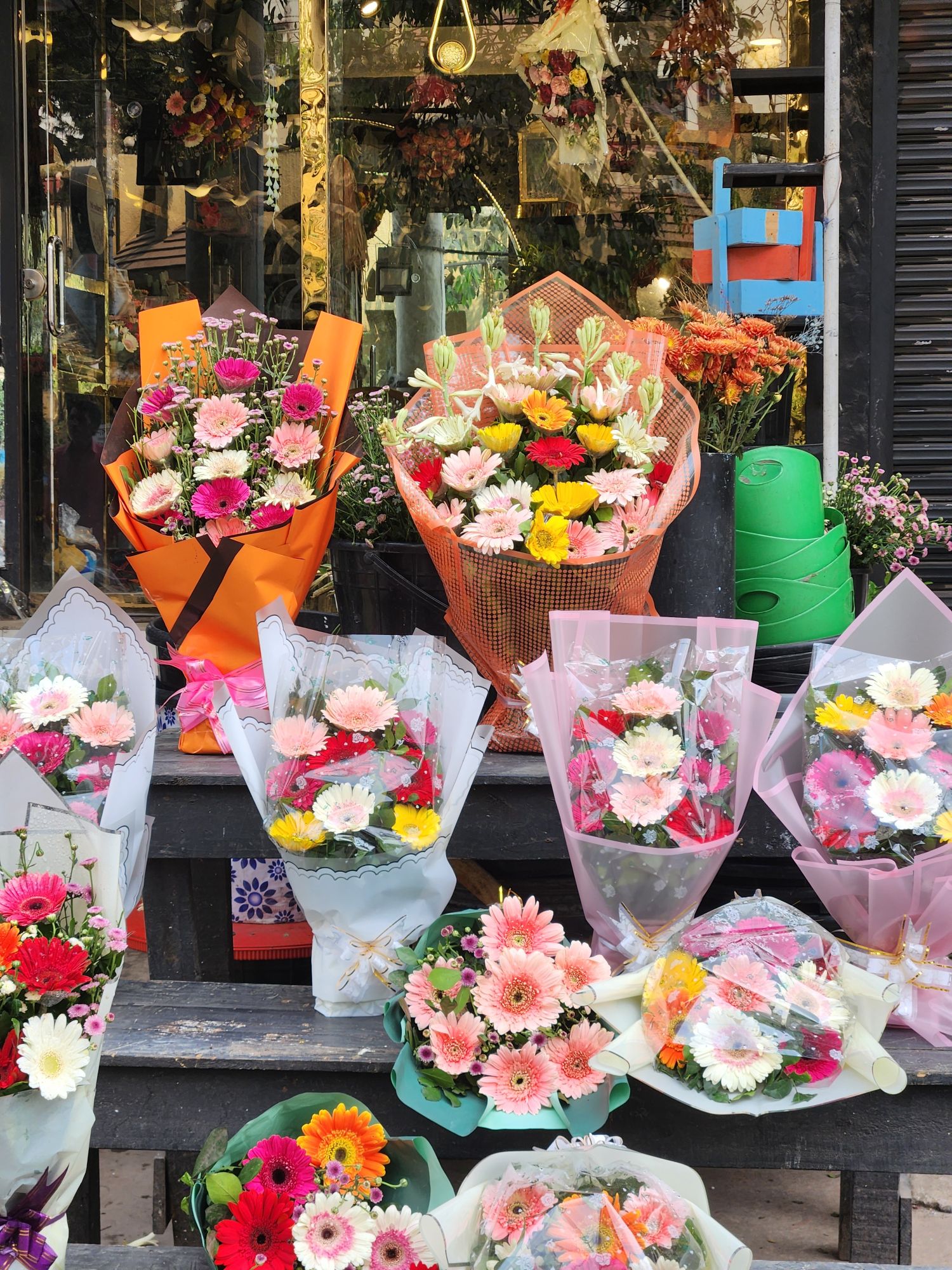 Bright gerbera bouquets on the shop steps