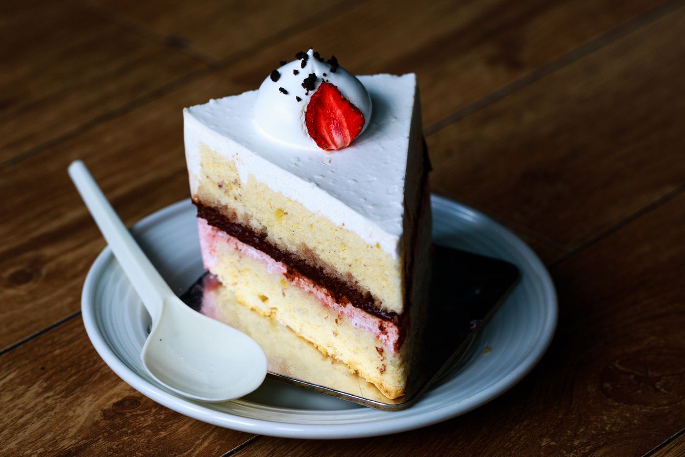 A layered sponge cake slice with cream and strawberry