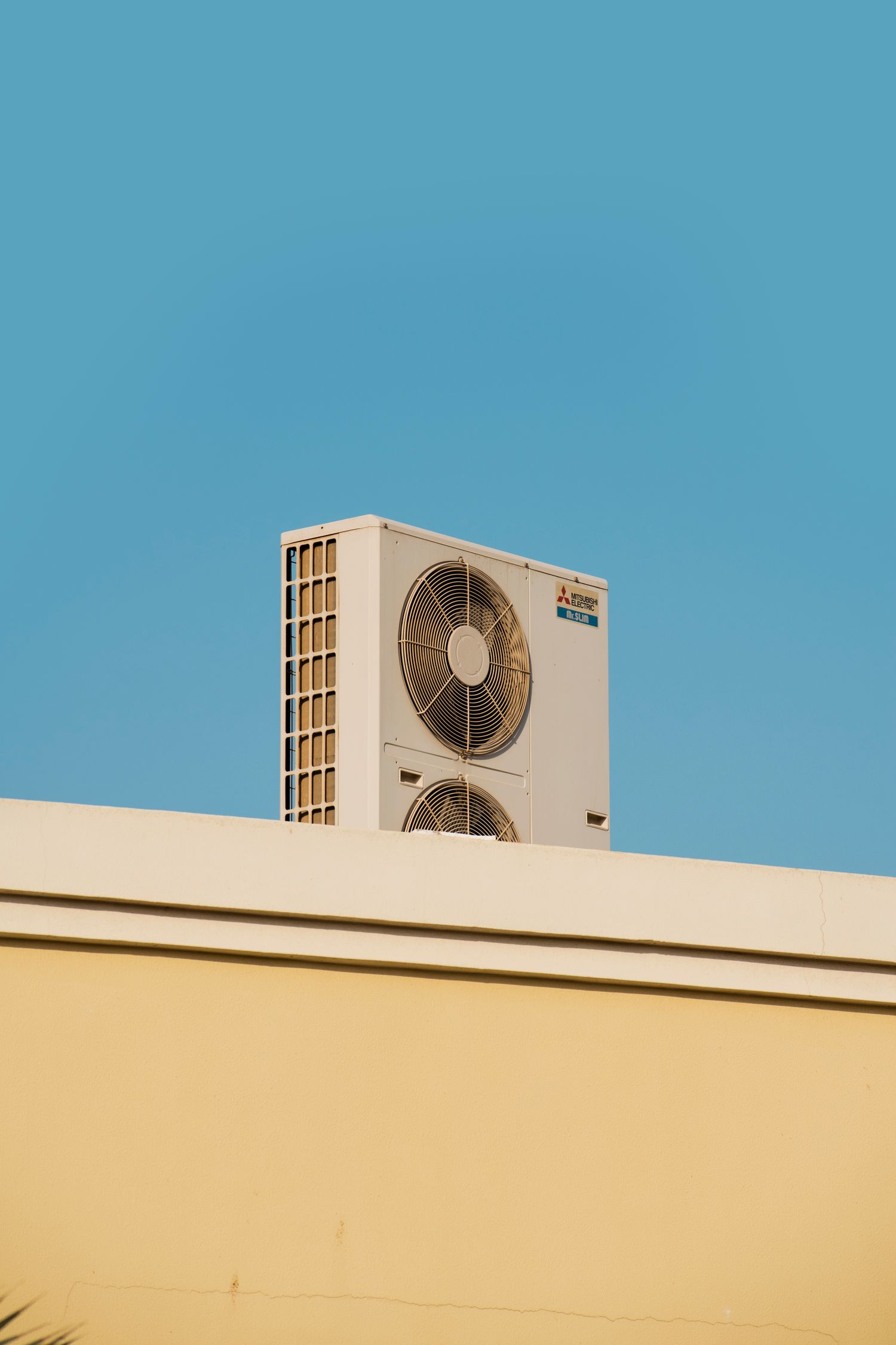 A condenser unit on a rooftop against blue sky