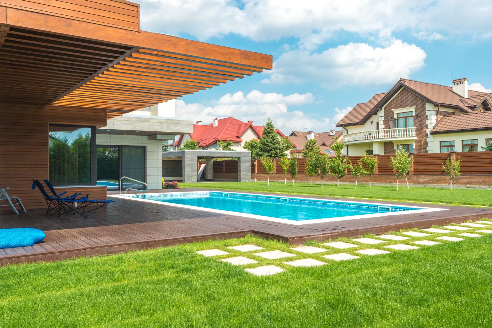 Modern backyard pool with wood deck and house behind