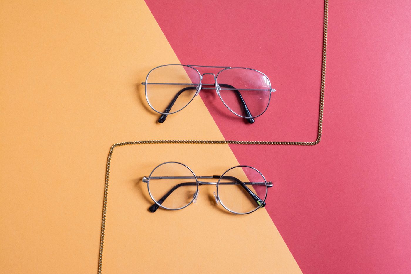 Designer eyeglass frames on a bold colour-block background