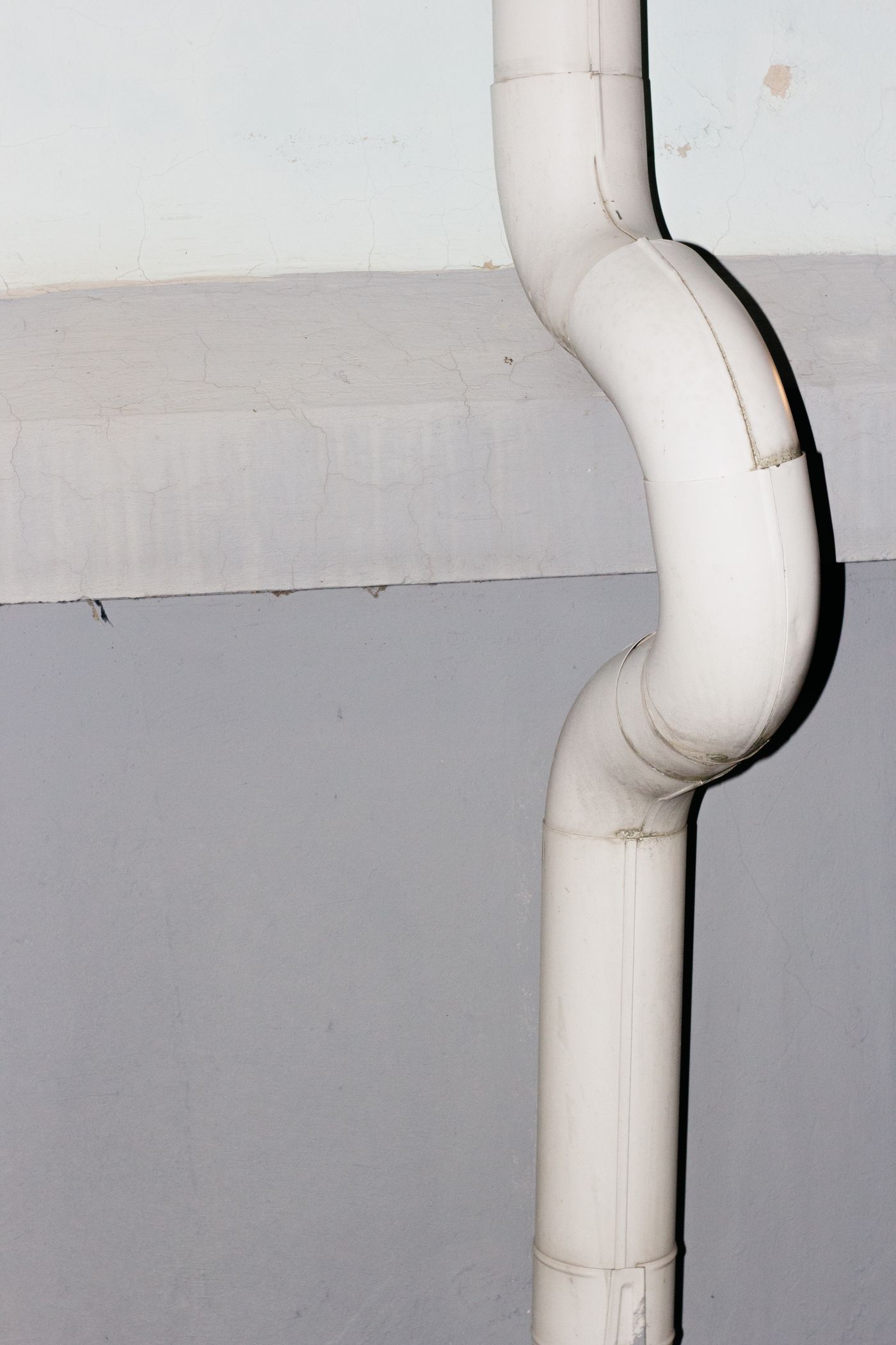 Clean white downspout and gutter run along an eave