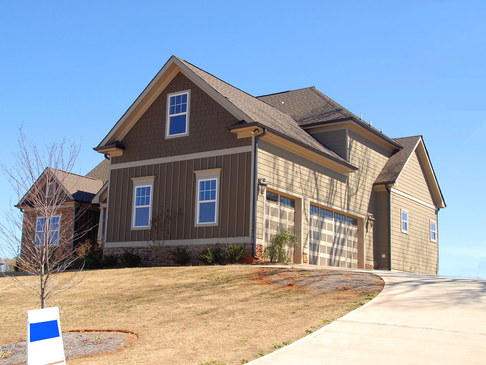 Two-storey home with a steep dark shingle roof
