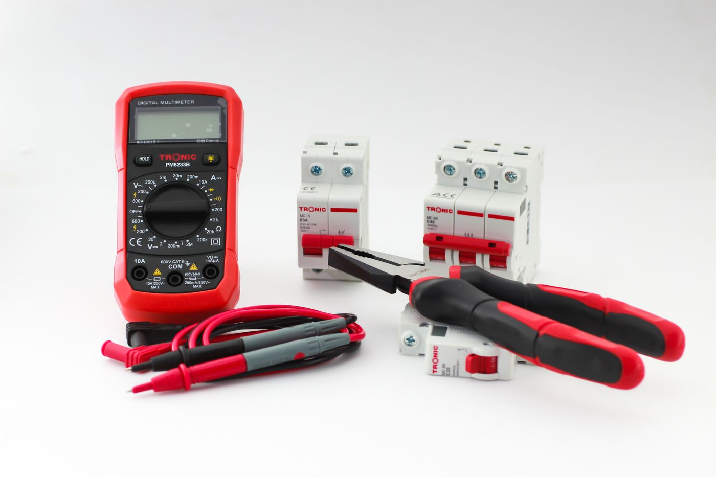 A multimeter, breakers and pliers laid out