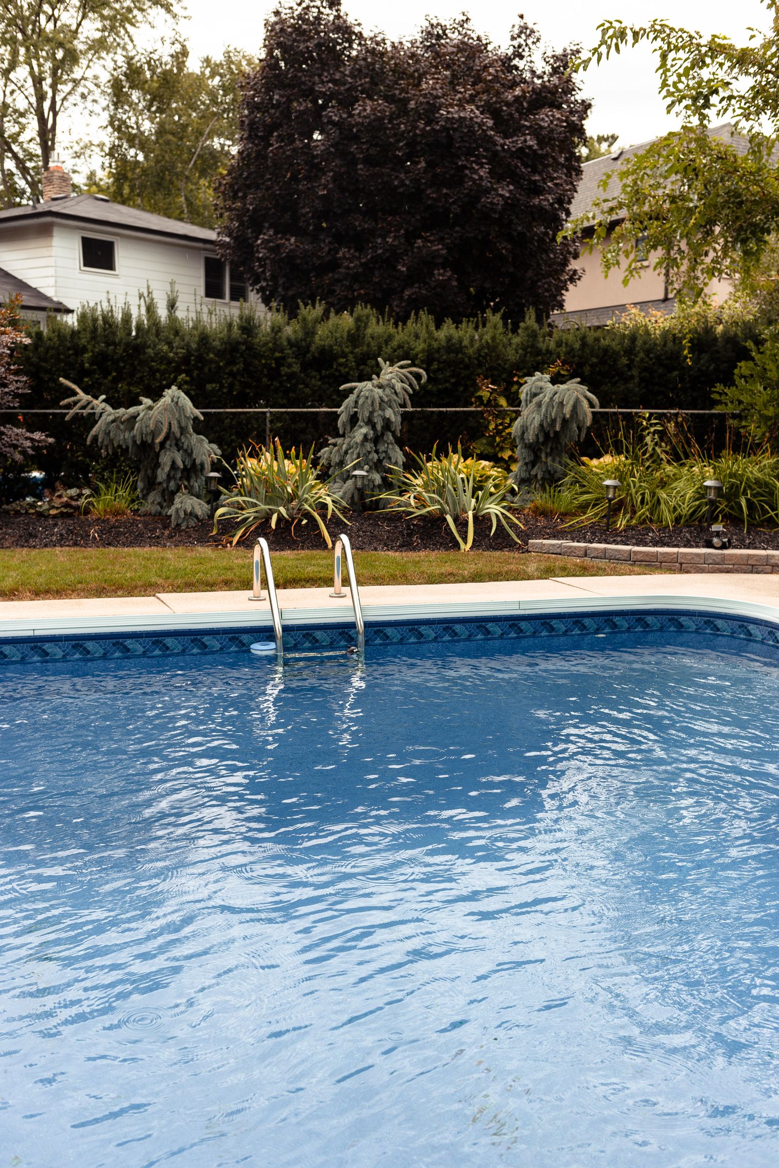 Residential vinyl-liner backyard pool with garden