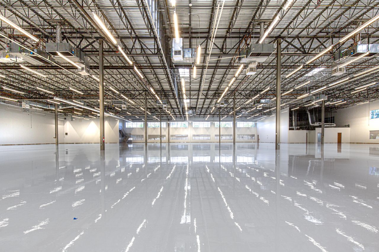 A glossy epoxy-coated warehouse floor reflecting the overhead lights