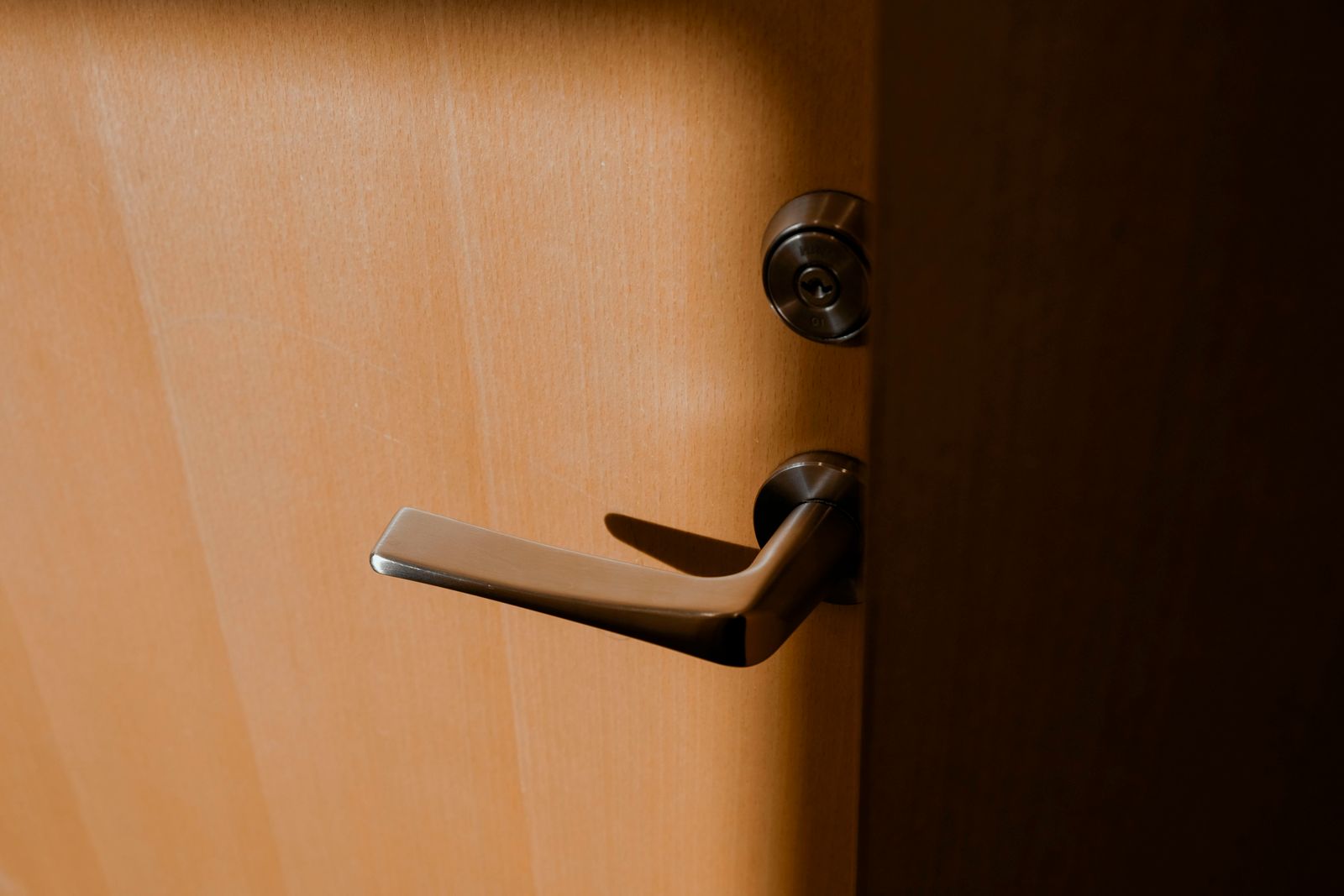 A lever handle with a keyed lock cylinder on a door